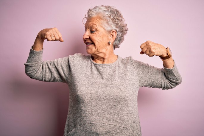 Seniorin zeigt stolz ihre Muskeln