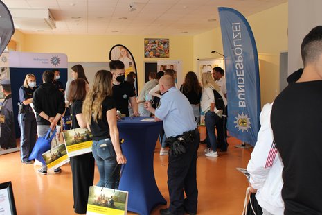 Junge Leute informieren sich am Messestand der Bundespolizei