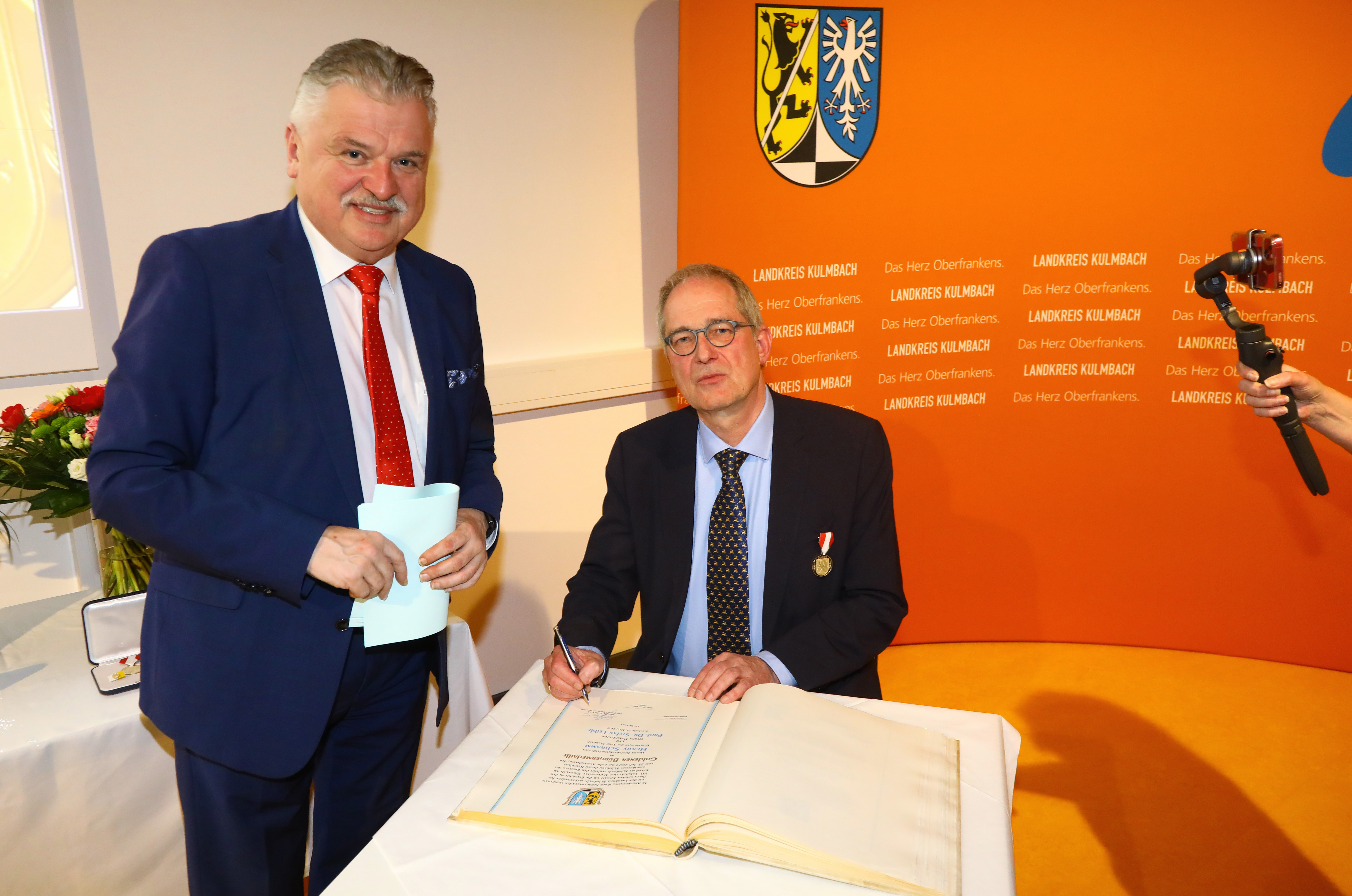 Eintrag ins goldene Buch durch Professor Leible